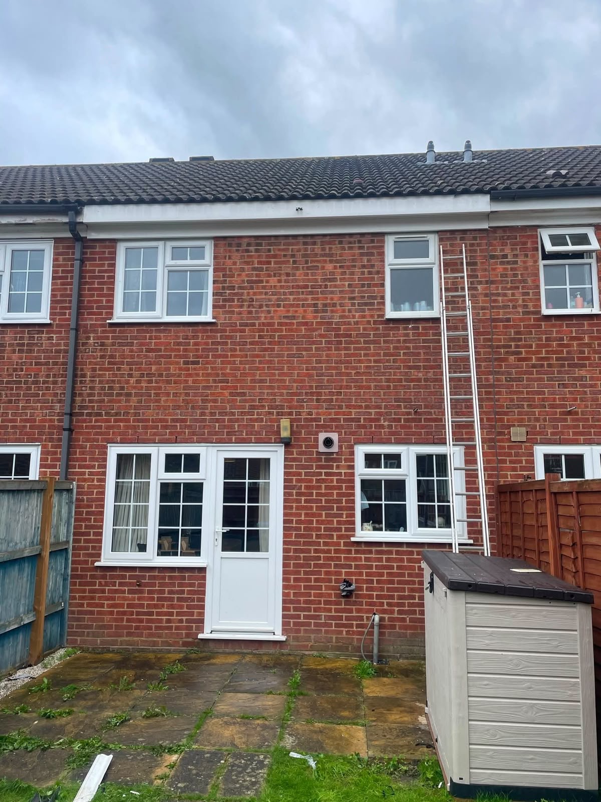Red brick house with ladder access for roofing work